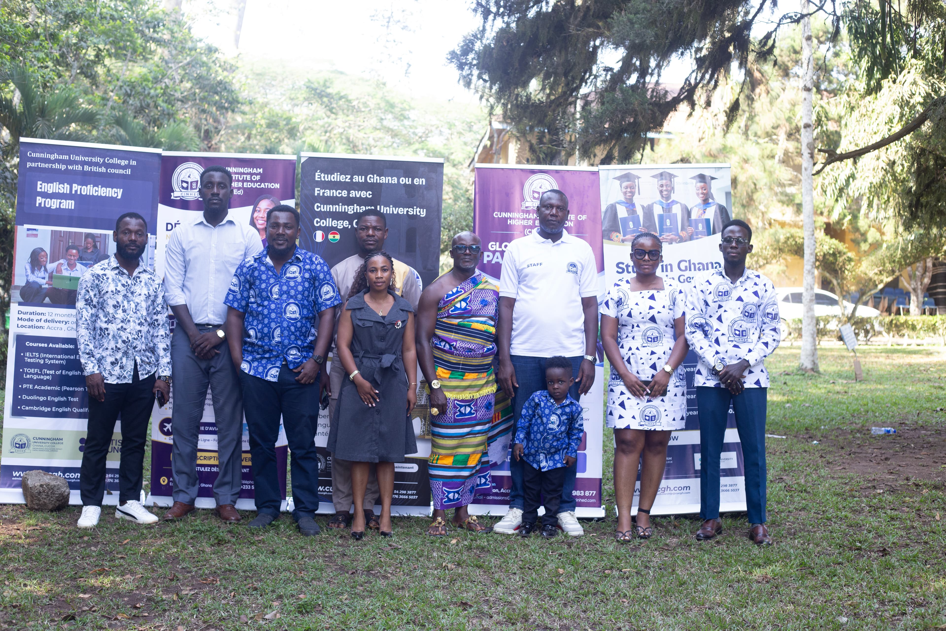 A group standing outdoors in front of Cunningham programme banners.